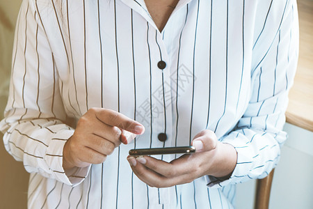 近女握着手机的空白版间用于您的广告短信或宣传内容女孩在咖啡休息时手机上观看图片