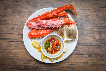 阿拉斯加国王螃蟹腿煮海鲜菜白盘上加柠檬酱红蟹北海道图片