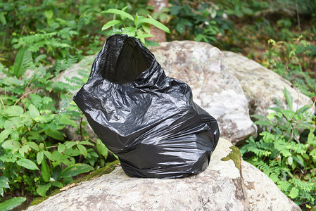 公园自然林中的黑垃圾袋清洁世界自然林拯救地球概念图片