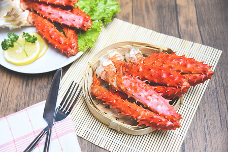 阿拉斯加国王螃蟹腿在木制桌子红蟹北海道用白板上的柠檬香料煮海鲜图片