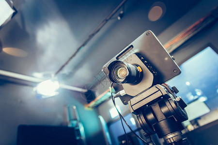 电视广播演室聚光灯和设备三脚架上的电影摄机图片