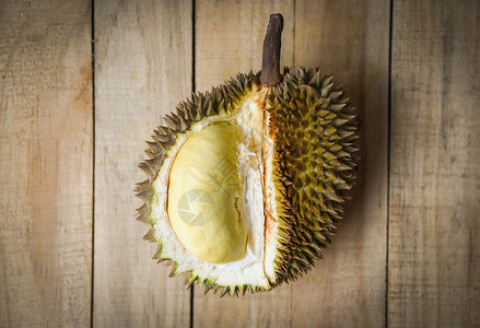 夏季Durian在木制背景料上撕扯新鲜的durian剥削热带水果图片