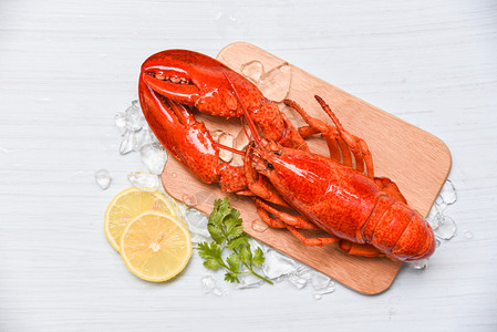 龙虾海鲜木制切板上加冰和柠檬椰菜关闭蒸龙虾食物高清图片