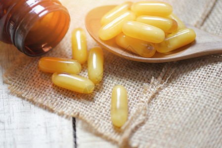 食五黄木勺和麻布背景黄胶囊药品或自然补充食用于健康背景