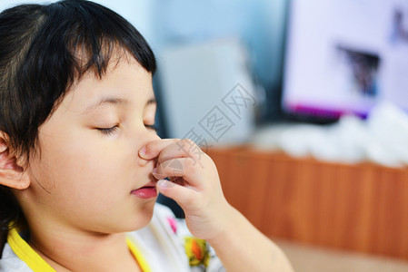 患着手握鼻子的亚洲女童生病后寒冷在流感季节抽鼻子儿童流涕和打喷嚏在家里鼻涕和发烧图片