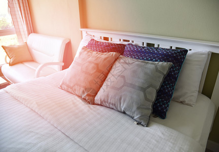 床上有枕头和毯子床铺有太阳清晨从窗户照亮图片