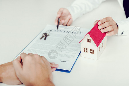家庭代理商正在寄笔给签订购买新房子合同的客户图片
