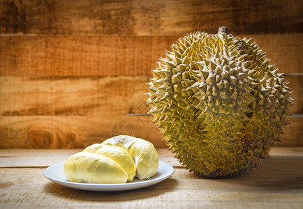 夏天Durian在木制背景上撕碎了盘子和土豆果夏天Durian在木制背景上撕扯了土豆果图片