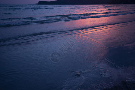 暗深海沙滩和红日晒落黄昏海洋背景图片