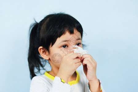 小女孩打柿子手帕包着生病的亚洲小女孩在流感季节寒冷和打鼻涕儿童流和打喷嚏在家里鼻涕和发烧背景