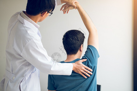 在医务室伸展一名年轻男子手臂背景图片