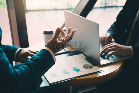两名商人在计算机屏幕上谈论公司财务报表的业结果图片
