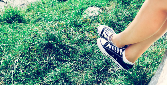 夏季的黑运动鞋和绿草青少年业余时间高清图片