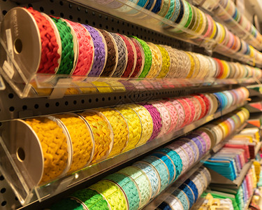 纺织业购物商场零售店的书架上堆满了多彩的缝纫线在书架上的缝纫线图片