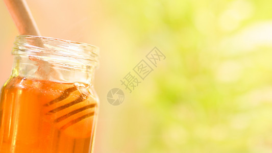 新鲜蜂蜜健康食品在罐中关闭甜蜂蜜罐中配有木制黄色和天然背景复制空间图片