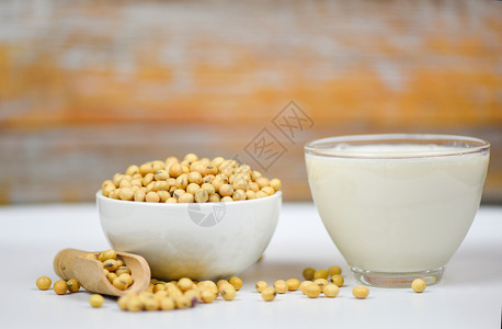 白碗上的豆和干玻璃中的奶用于健康饮食料和天然豆蛋白背景图片