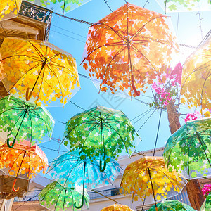 夏天阳光明媚的日子街上装饰着多彩的雨伞图片