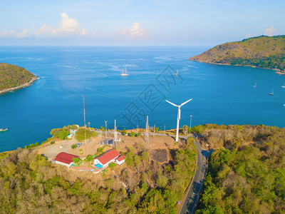 夏季在泰国普吉岛旅行时在Patong海滩看到一个风轮机上有蓝色绿宝石海水热带绿林树和安达曼海还有自然背景图片