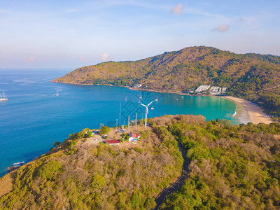 夏季在泰国普吉岛旅行时在Patong海滩看到一个风轮机上有蓝色绿宝石海水热带绿林树和安达曼海还有自然背景图片