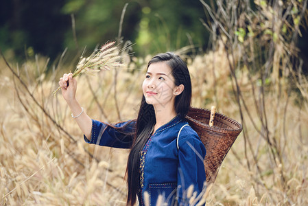 亚洲种植草地的女农民美丽的亚洲年轻女孩快乐微笑的肖像与农村收割业的篮子一模样着装部落生活背景图片