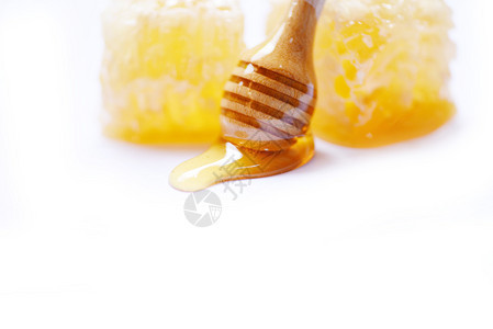 近的蜂蜜白色背景的蜂蜜与木和窝蜜黄色甜的大自然图片