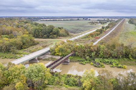 与密西比河交汇的伊利诺州Cache河对面的废弃铁路桥和横跨Cache河坠落风景的空中观察图片