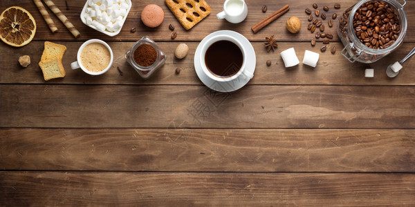 木制背景表格上方的咖啡和豆子图片