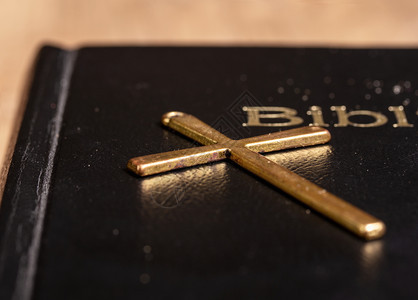 圣经在黑暗的遮盖下紧贴着并有一个金属铜躺在它上面圣经背景图片