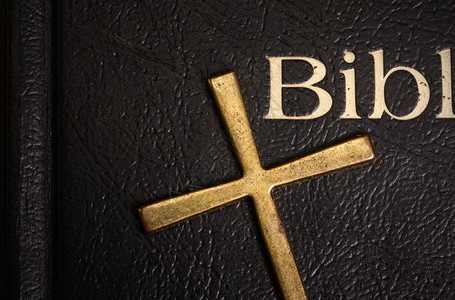 圣经在黑暗的遮盖下紧贴着并有一个金属铜躺在它上面圣经图片