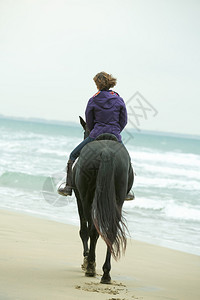 女孩在海滩上骑马图片
