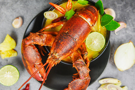 红龙虾辣汤碗煮的海鲜加上龙虾晚饭桌和黑盘泰餐上的香料成分TomYumKung图片