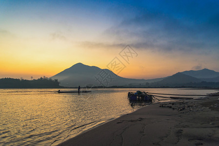 在湄公河亚洲渔船上的海滨夫风景鲜明的海边滨美丽的日出和山地背景的色彩多天空湄公河亚洲图片
