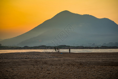 亚洲湄公河流域的风景海滩和渔民美丽的日出和山地背景的多彩天空图片