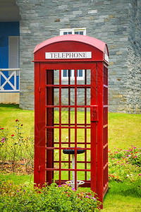 古老的英语红色调用箱公园花的旧式电话箱图片