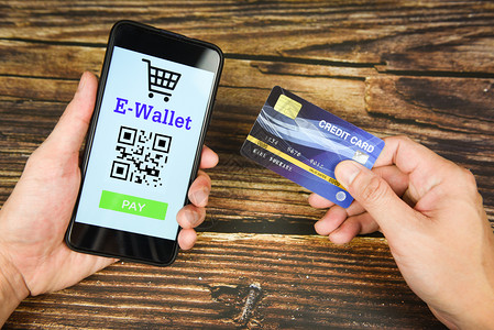 手机卡片拥有手持信用卡和电子钱包应用程序的智能手机技术付费在线购物使用技术电子钱包概念背景