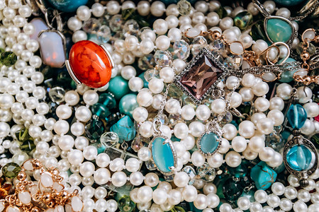 由彩色半宝石制成的珠子和项链背景来自各种美丽的珠宝多色绿石琥珀猫和龙舌头眼睛珍珠背景图片