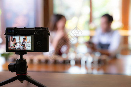 VLOG的年轻成人作为业主对咖啡店进行审查并生活在社交媒体中咖啡馆用相机进行在线营销使用小商业制造和消费主义概念启动图片