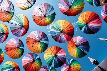 蓝天空背景彩虹颜色的伞状图片