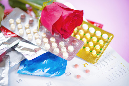 安全爱概念带避孕套和日历背景玫瑰的计划生育停止怀孕或传染疾病图片
