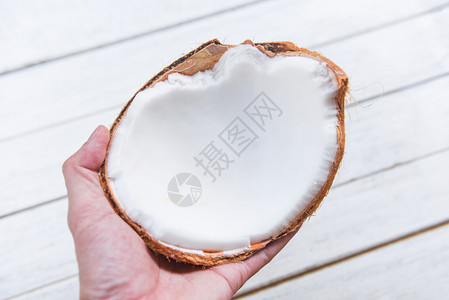 椰子水果的一半椰子牛奶在表格背景上手头的椰子牛奶图片