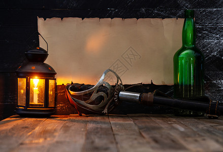 古老的横向卷轴在黑木墙上放文字的地方用酒精和火蜡烛的灯笼制成钢杯绿瓶和灯笼用黑木墙上的钢图片