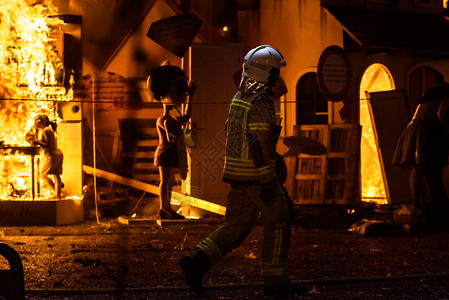 消防员和他的护服负责控制巴伦西亚节日法拉号的燃烧图片