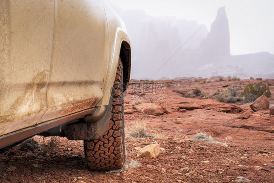 SUV越野车在泥土路上前轮胎细节特写图片