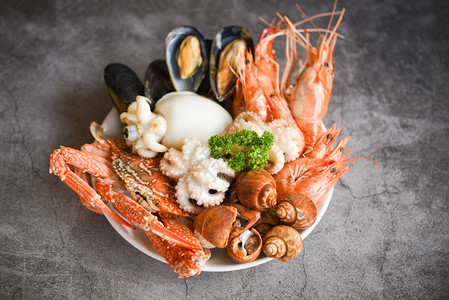 海产虾鱿鱼贝发现盘上和深底盘上有比龙贝壳螃蟹厨食为海鲜自助餐提供食物的概念图片