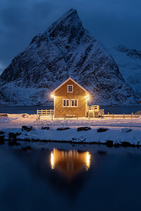 夜间的家小屋或房雷因市挪威渔业村洛福滕岛诺德兰县挪威欧洲白雪山冬季自然景观背图片