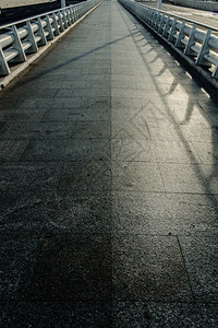 一条长的大理石砖路白色金属栏杆地平线上一条消失的空无一人方向的概念图片