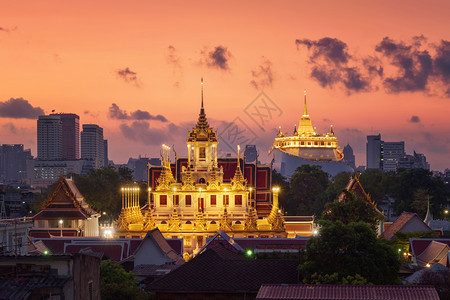 LohaPrasatWatRatchanatta和金山塔是佛教寺庙或WatSaket在曼谷市中心有摩天大楼日落时在泰国城市图片