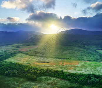 云层中的太阳光照耀着山上的绿谷自然构成景观图片