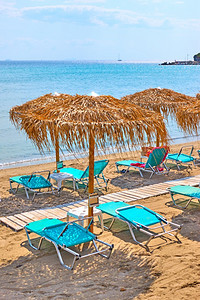 在阳光明媚的夏日沙滩和草伞在海边的图片