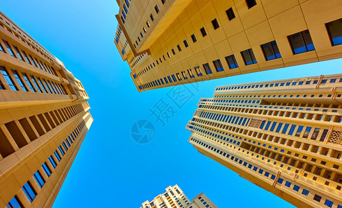 现代多层公寓楼对蓝色天空的视角图片